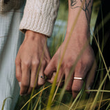 Close-up of two hands holding each other with grass in the foreground