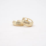 Two gold hoop earrings on a white background
