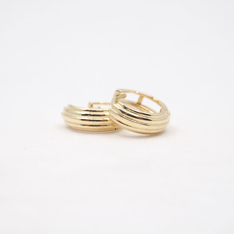 Two gold hoop earrings on a white background