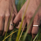 Close-up of two hands holding each other with grass in the foreground