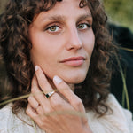 Woman with curly hair wearing rings, outdoors