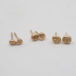 Set of gold earrings on a light gray background