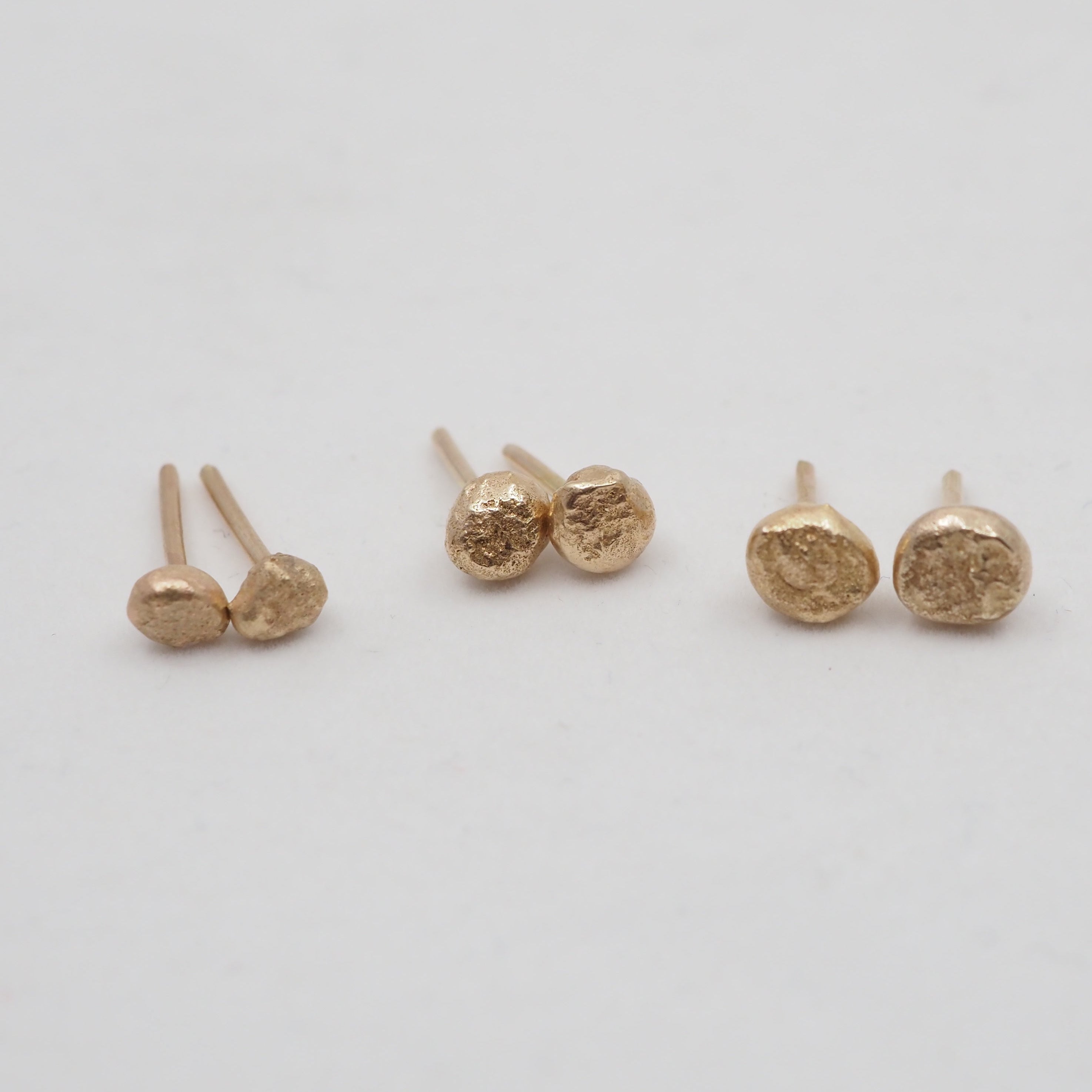 Set of gold earrings on a light gray background