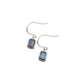 Silver earrings with blue-grey gemstones on a light gray background