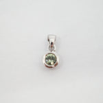 A sterling silver pendant featuring a bezel-set round light green gemstone, shown against a plain light gray background.
