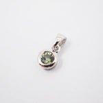 A sterling silver pendant featuring a bezel-set round green gemstone, shown on a clean white background.