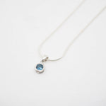 Necklace with a blue gemstone pendant on a white background