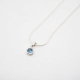 Necklace with a blue gemstone pendant on a white background