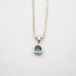 Necklace with a blue gemstone pendant on a white background