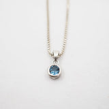 Necklace with a blue gemstone pendant on a white background