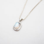 Necklace with a pendant featuring a rainbow labradorite stone on a light gray background