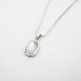 Necklace with a pendant featuring a rainbow labradorite stone on a light gray background