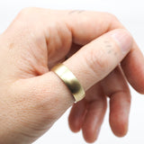 Gold ring on a finger against a white background
