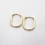Gold hoop earrings on a light gray background