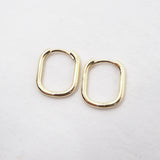 Gold hoop earrings on a light gray background