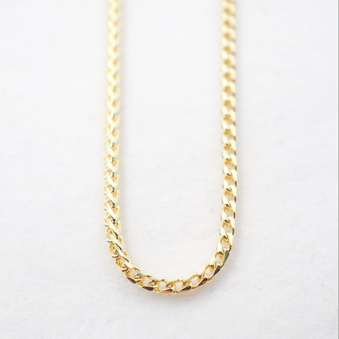 Gold chain on a light gray background