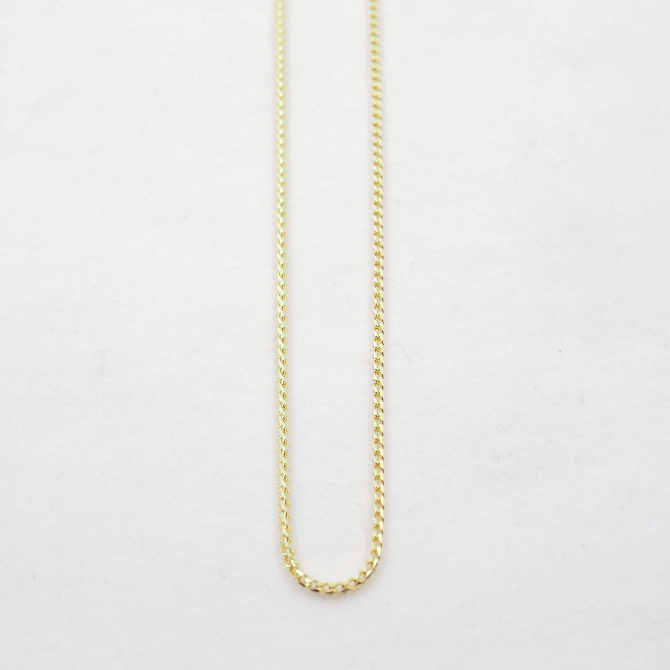 Gold chain on a light gray background