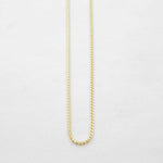 Gold chain on a light gray background