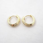 Pair of gold hoop earrings on a light gray background