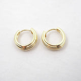 Pair of gold hoop earrings on a light gray background