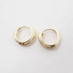 Gold hoop earrings on a light gray background