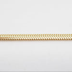 Gold chain on a light gray background
