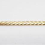 Gold chain on a light gray background