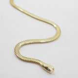 Gold chain bracelet on a light gray background