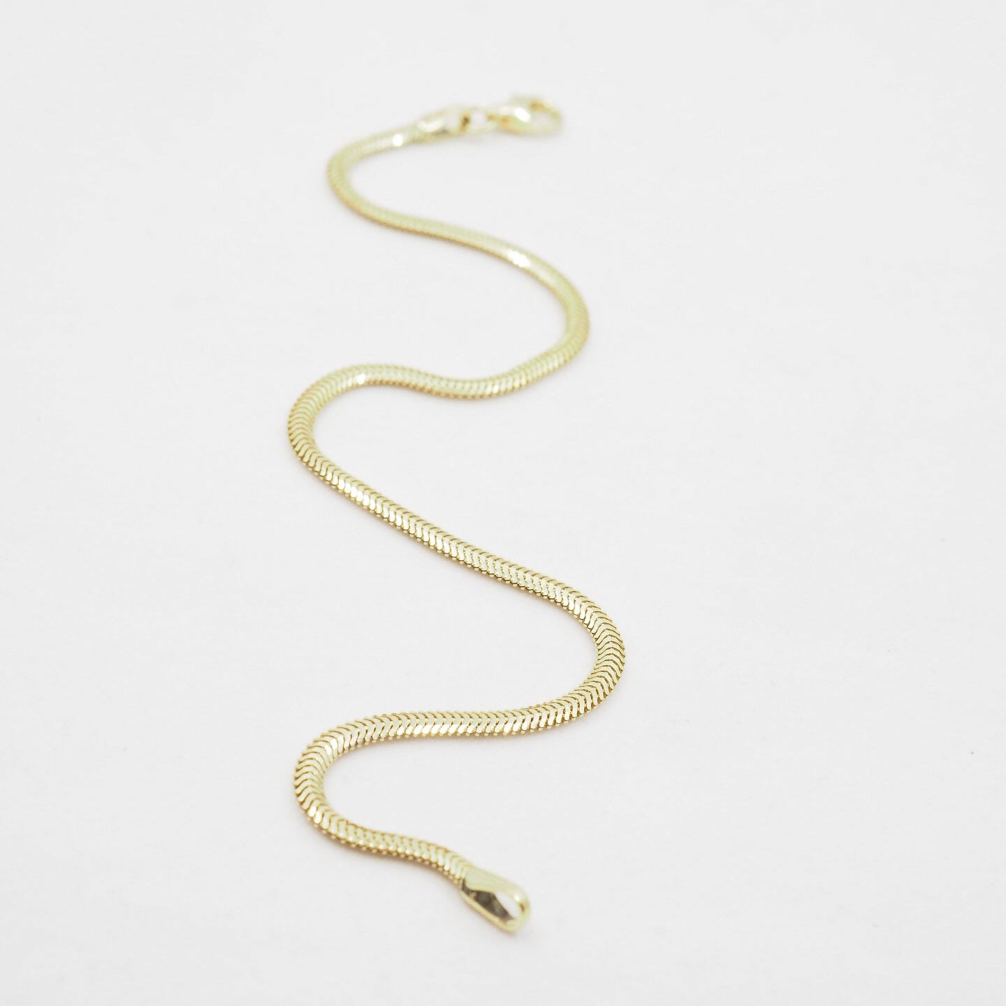 Gold chain bracelet on a white background