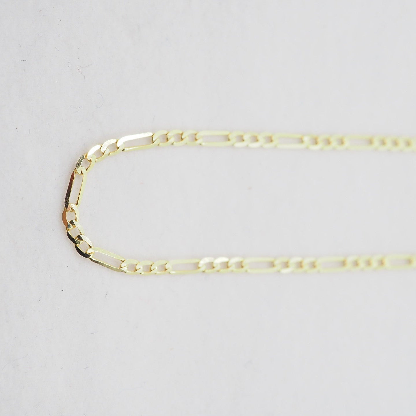 Gold chain on a light gray background