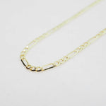 Gold chain necklace on a light gray background