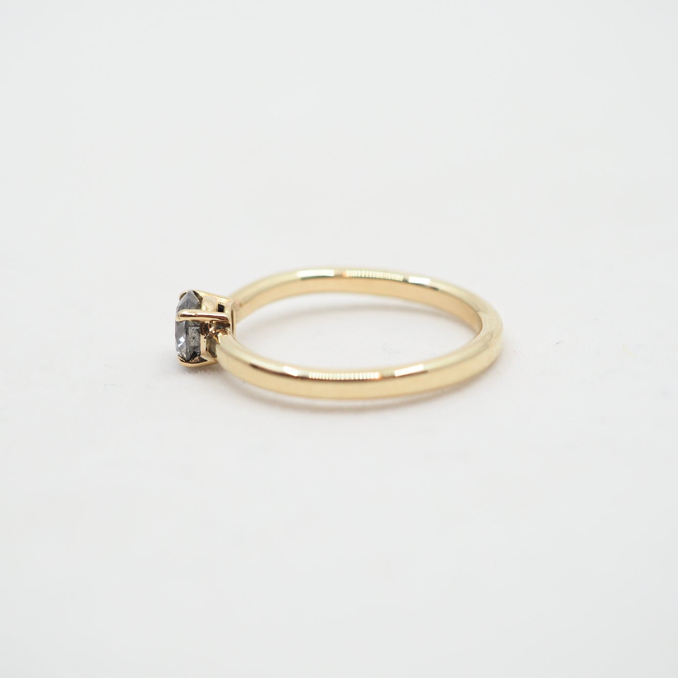 Gold ring with a small gemstone on a light gray background