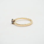 Gold ring with a small gemstone on a light gray background