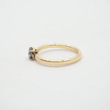 Gold ring with a small gemstone on a light gray background