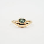Gold ring with a green gemstone on a white background