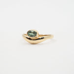 Gold ring with a green gemstone on a white background