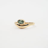 Gold ring with a green gemstone on a white background