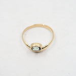Gold ring with a green gemstone on a white background