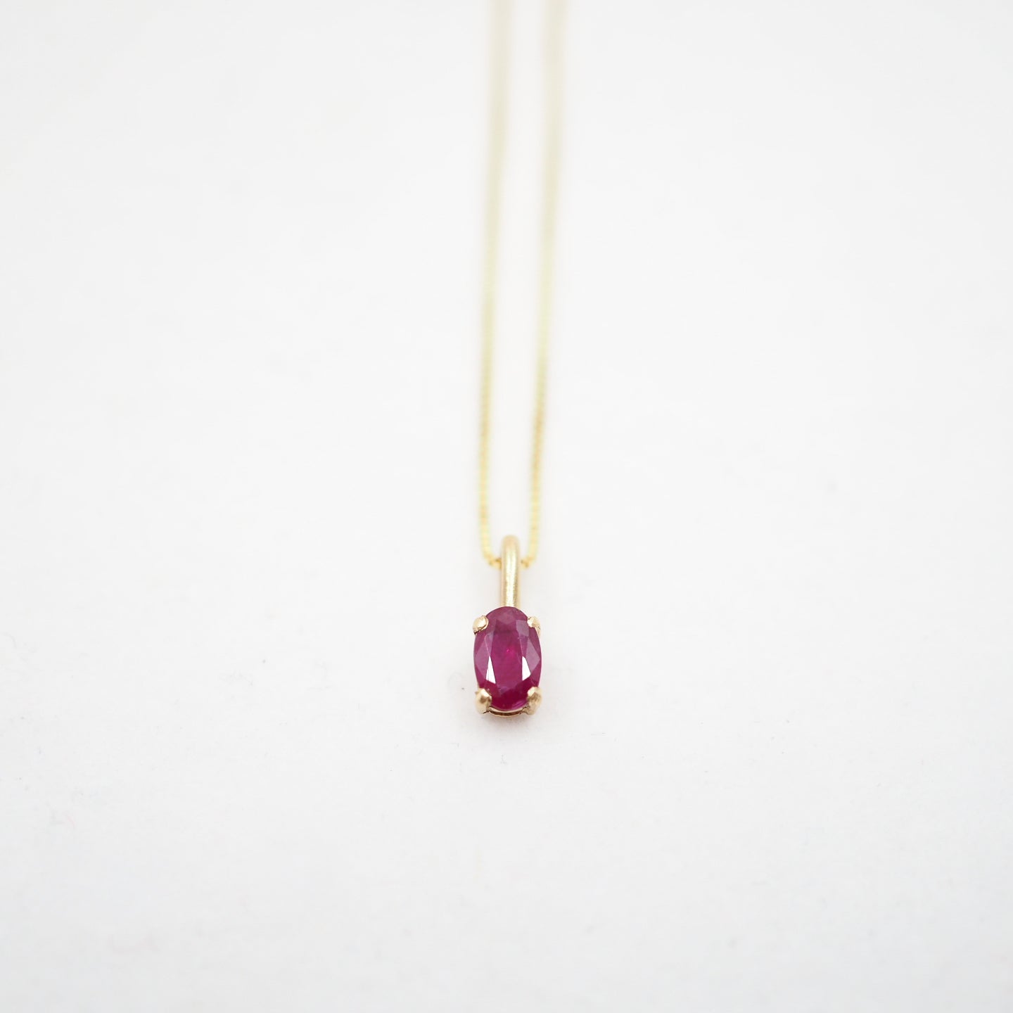 Necklace with a red gemstone pendant on a white background