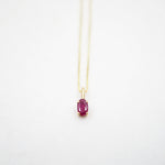 Necklace with a red gemstone pendant on a white background