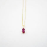 Necklace with a red gemstone pendant on a white background
