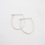 Silver hoop earrings on a light gray background