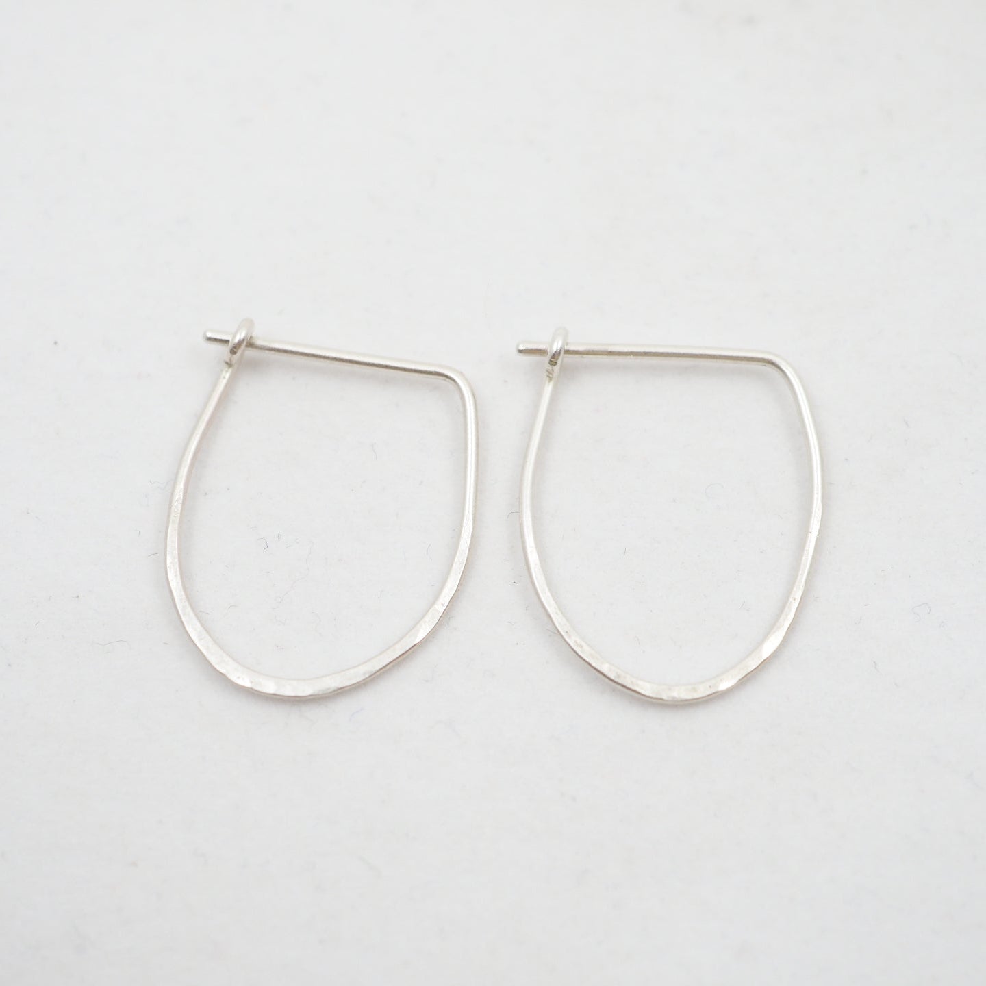 Pair of silver hoop earrings on a white background