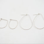 Set of four silver hoop earrings on a white background