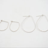 Set of four silver hoop earrings on a white background