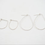 Set of four silver hoop earrings on a white background