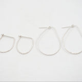 Set of four silver hoop earrings on a white background