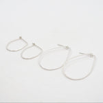 Pair of silver hoop earrings on a white background