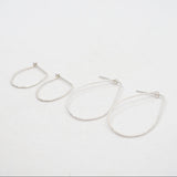Pair of silver hoop earrings on a white background