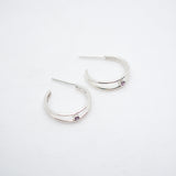 Pair of silver hoop earrings on a light gray background